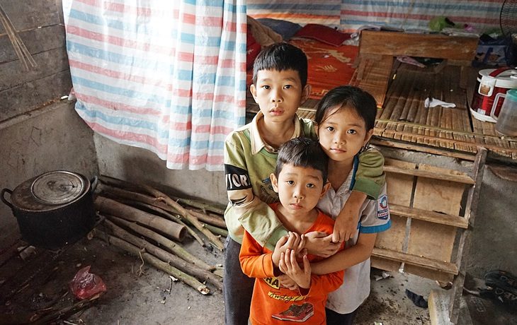 Ba đứa bé Thành Long, Ngọc Hoa, Minh Tân đang sống nhờ chuồng lợn cũ của người bác - Ảnh: VŨ TUẤN