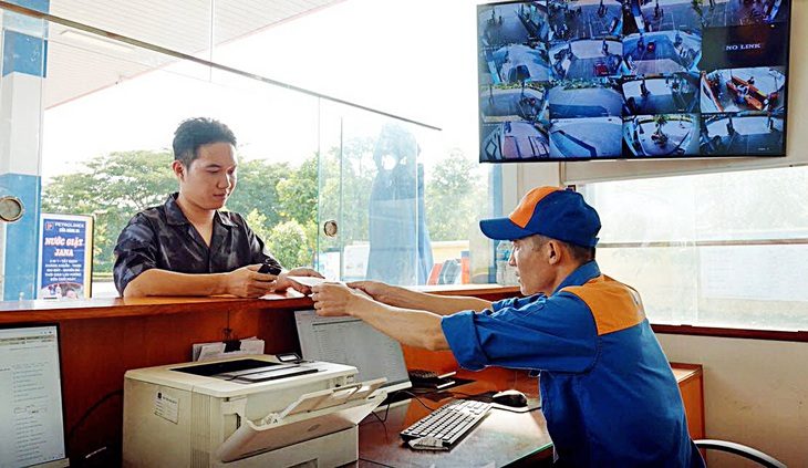 Nhân viên cửa hàng Petrolimex xuất hóa đơn giấy từ hệ thống hóa đơn điện tử cho khách hàng tại cửa hàng xăng dầu ở Hà Nội - Ảnh: N.KH.